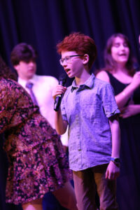 A young singer performs with a group at our 2023 concert.